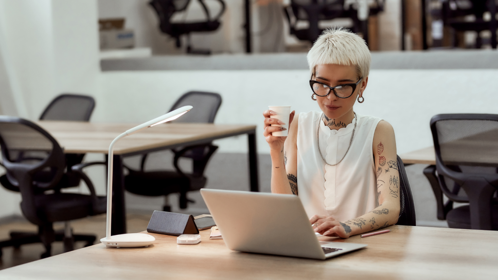 A tattooed professional enjoying a coffee.