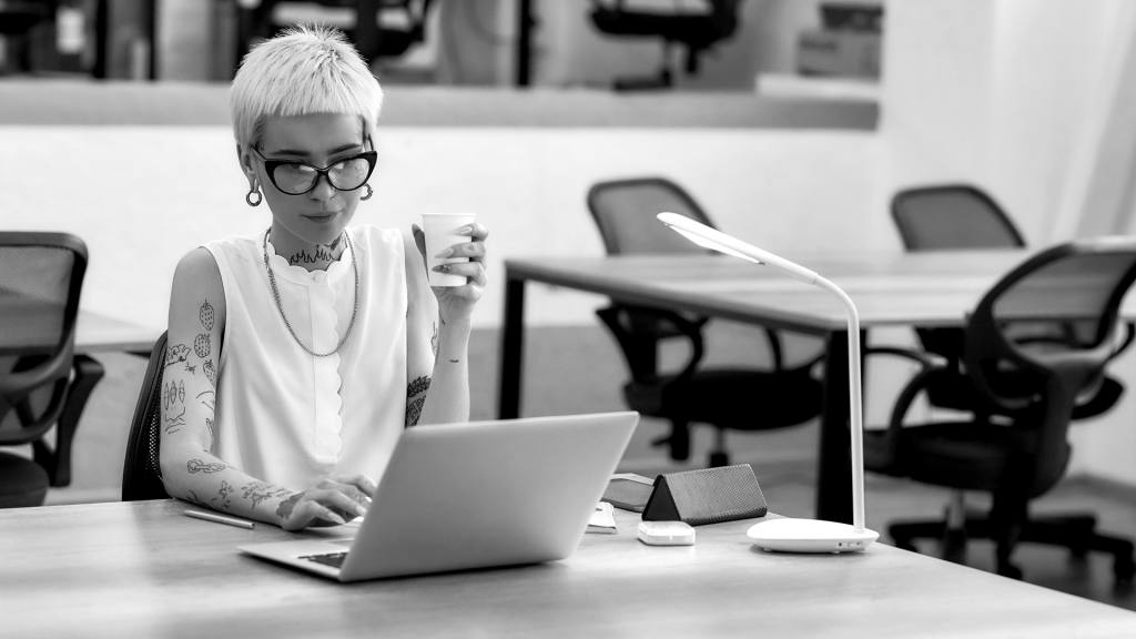 A tattooed professional enjoying a coffee.