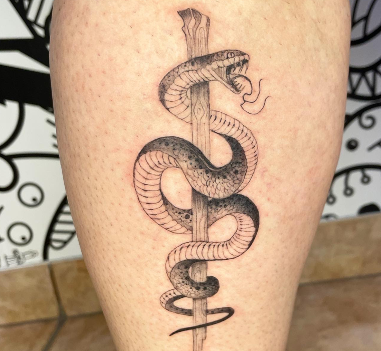 Rod of Asclepius fine-line and realism tattoo.