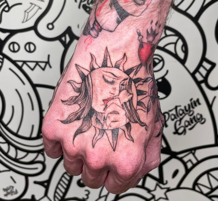 Retro girl in sun on hand tattoo.