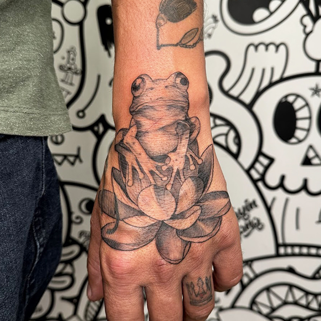 Frog and lotus hand tattoo